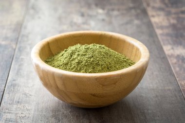 Ahşap arka plan üzerinde bir kasede Matcha yeşil çay