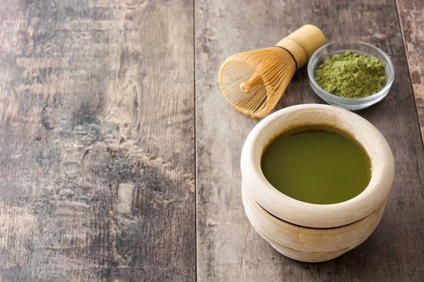 Ahşap arka plan üzerine bir kase ve bambu çırpma teli Matcha yeşil çay — Stok fotoğraf