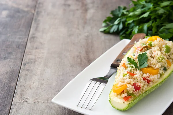 Stuffed zucchini with quinoa and vegetables on wooden background — Stock Photo, Image