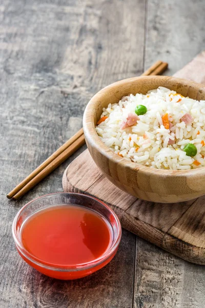 Жареный китайский рис с овощами на деревянном фоне — стоковое фото