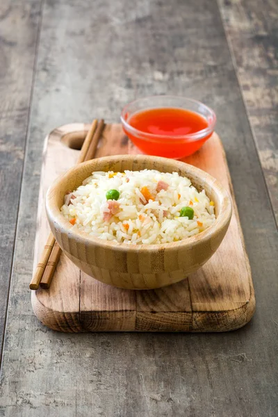Жареный китайский рис с овощами на деревянном фоне — стоковое фото