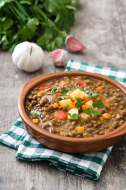 Ahşap arka plan üzerinde bir kasede mercimek çorbası