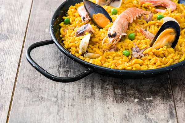 Paella tradicional española de mariscos sobre fondo de madera . — Foto de Stock