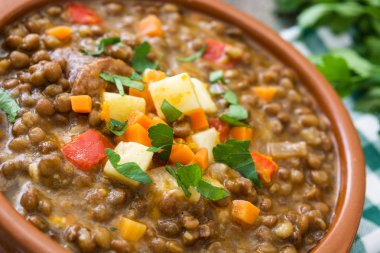 Ahşap arka plan üzerinde bir kasede mercimek çorbası