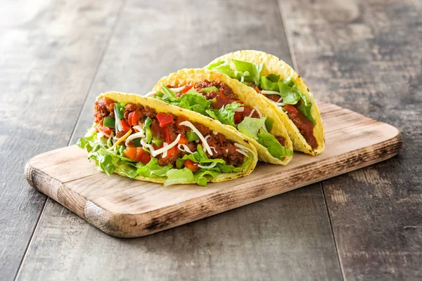 Traditionele Mexicaanse taco's met vlees en groenten op houten achtergrond — Stockfoto