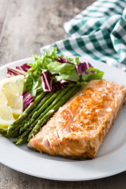 Kuşkonmaz ve ahşap masa plaka salata ızgara somon fileto