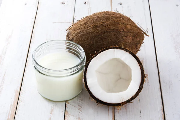 Coconut and coconut milk on white wooden table — Stock Photo, Image