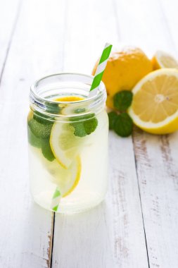 Beyaz ahşap zemin üzerinde bir kavanoz cam limonata iç. Boşaltmak.