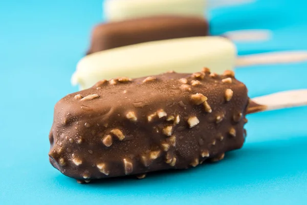 Csokoládé fagylalt popsicles elszigetelt kék háttér. — Stock Fotó