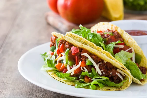 Traditionele Mexicaanse taco's met vlees en groenten op houten achtergrond — Stockfoto