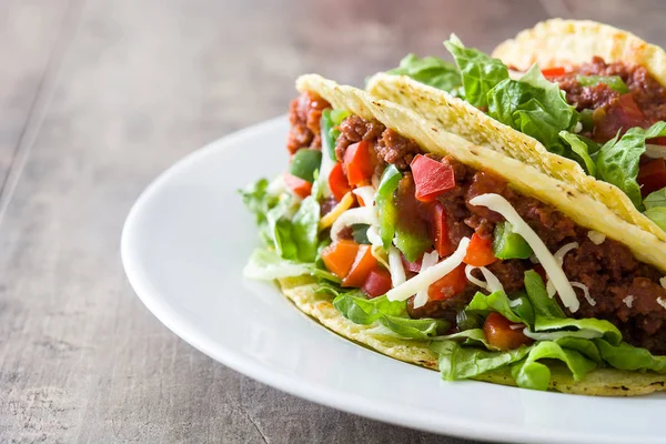 Tacos mexicanos tradicionales con carne y verduras sobre fondo de madera — Foto de Stock