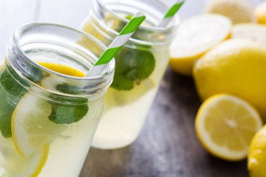 Ahşap arka plan üzerinde bir kavanoz cam limonata içmek. 