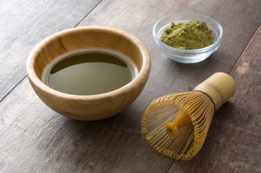 Bir kase ve bambu çırpma teli ahşap masa üzerinde Matcha yeşil çay