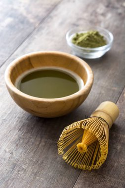 Bir kase ve bambu çırpma teli ahşap masa üzerinde Matcha yeşil çay