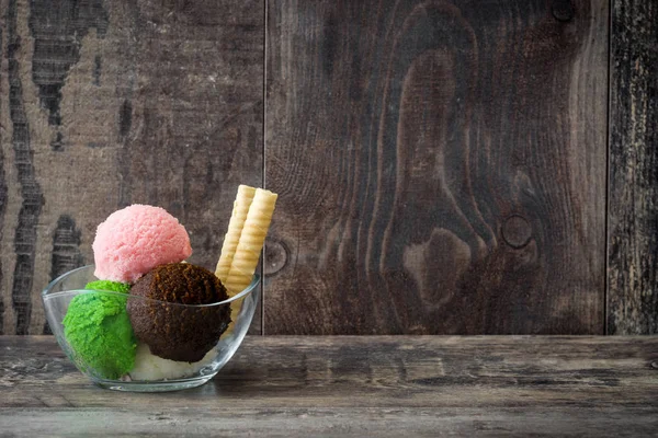 Ice cream scoops in crystal bowl on white wooden background. — Stock Photo, Image