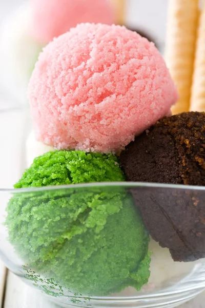 Ice cream scoops in crystal bowl on white wooden background. — Stock Photo, Image