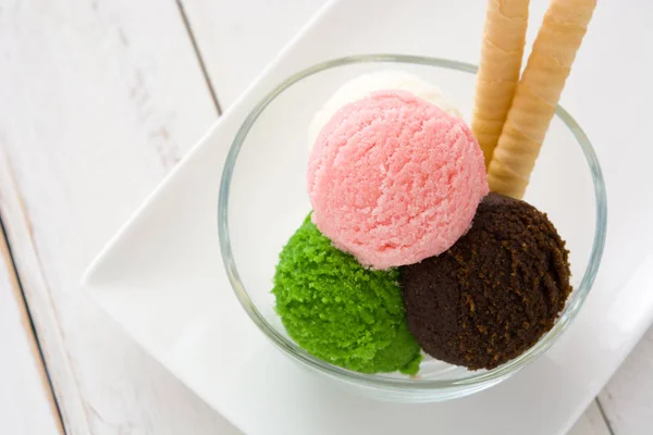 Cuillères à crème glacée dans un bol en cristal sur bois blanc — Photo