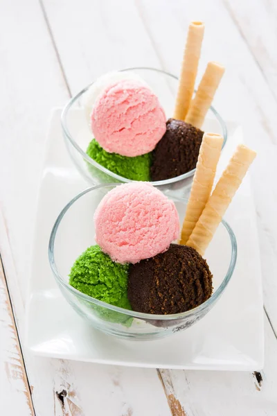 Ice cream scoops in crystal bowl on white wooden background. — Stock Photo, Image