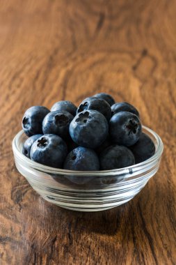 Kristal kase ahşap arka plan üzerinde yaban mersini