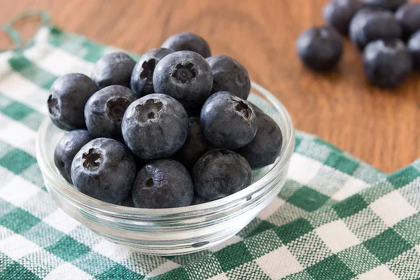 Blueberries in crystal bowl on wooden background