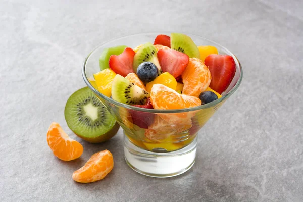 Fruit salad in crystal bowl on gray stone