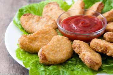 Kızarmış tavuk külçeleri ahşap masada.