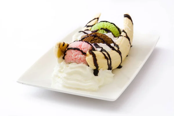 Десерт из бананового мороженого с шоколадным сиропом на белом фоне — стоковое фото