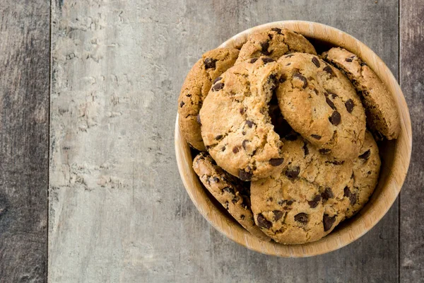 Čokoláda čip cookies v dřevěné misce na dřevěný stůl. Pohled shora — Stock fotografie