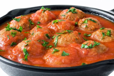 Meatballs with tomato sauce in iron frying pan isolated on white background clipart