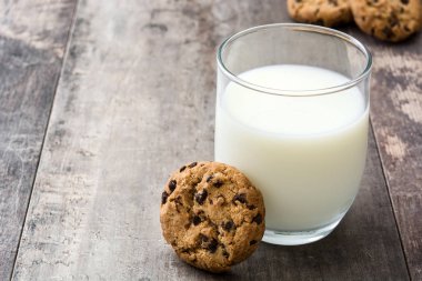 Çikolatalı kurabiye ve süt ahşap masa arka plan üzerinde