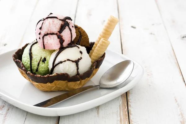 Ice cream scoops served in waffle basket on white wooden table — Stock Photo, Image