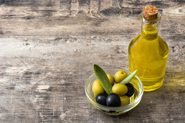 Оливковое масло в хрустальной бутылке на деревянном столе — стоковое фото