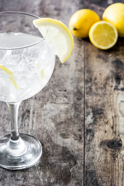 Glas gin tonic met citroen op houten achtergrond — Stockfoto