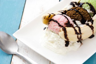 Muzlu dondurma tatlı beyaz ve mavi ahşap masa üzerinde çikolata şurubu ile bölme