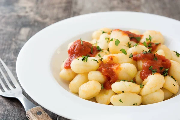 Gnocchi con salsa de tomate sobre fondo de madera — Foto de Stock