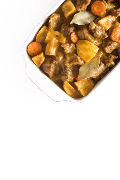 Rundvlees, gestoofd met aardappelen, wortelen en specerijen in keramische pot geïsoleerd op een witte achtergrond. Bovenaanzicht — Stockfoto