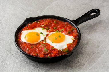 Meksika Kahvaltı: Huevos rancheros demir tavada gri taş