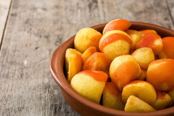 Patatas bravas in bowl on wooden table — Stock Photo, Image