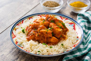 Ahşap arka plan üzerinde pilavlı tavuk tikka masala