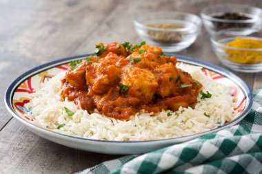Ahşap arka plan üzerinde pilavlı tavuk tikka masala