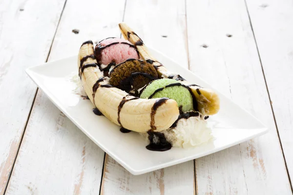 Banana split glass dessert med choklad sirap på vitt trä bord — Stockfoto