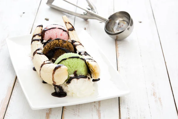 香蕉冰淇淋甜点与白色木制的桌子上的巧克力糖浆 — 图库照片