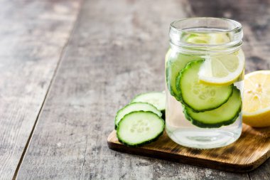 Su ile salatalık ve ahşap masa üzerinde Limon Detoks