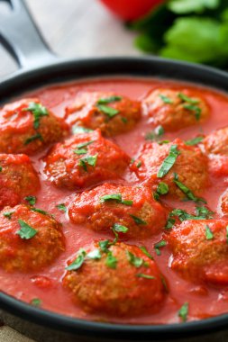Ahşap masa üzerinde demir tavada domates soslu köfte