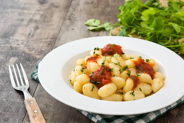 Gnocchi con salsa de tomate sobre fondo de madera — Foto de Stock