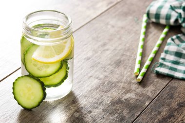 Su ile salatalık ve ahşap masa üzerinde Limon Detoks