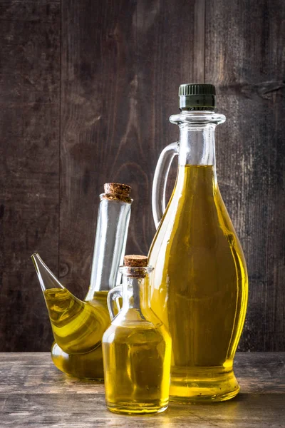 Aceite de oliva virgen en una botella de vidrio sobre fondo de madera . — Foto de Stock