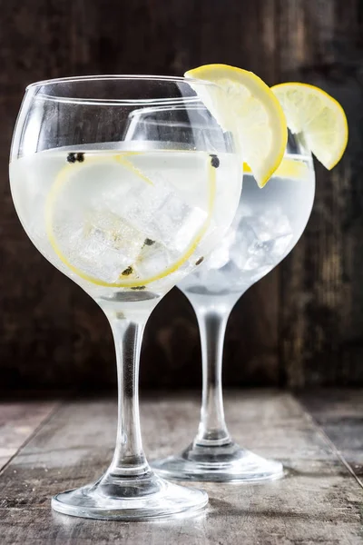 Glass of gin tonic with lemon on wooden background — Stock Photo, Image