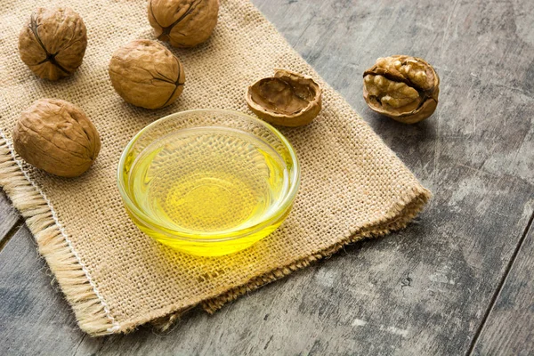 Walnuts oil on wooden background — Stock Photo, Image