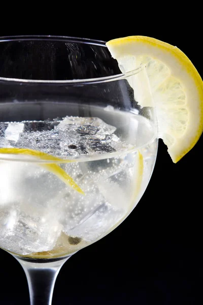 Glass of gin tonic with lemon on black stone background — Stock Photo, Image